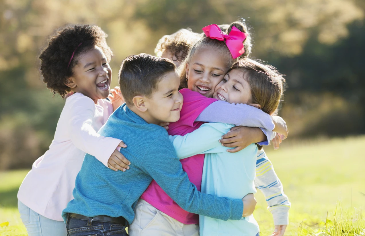 Children playing outdoors hugging - Maryvale